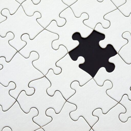 Close-up of an incomplete white puzzle with one missing piece, symbolizing challenge and strategy.