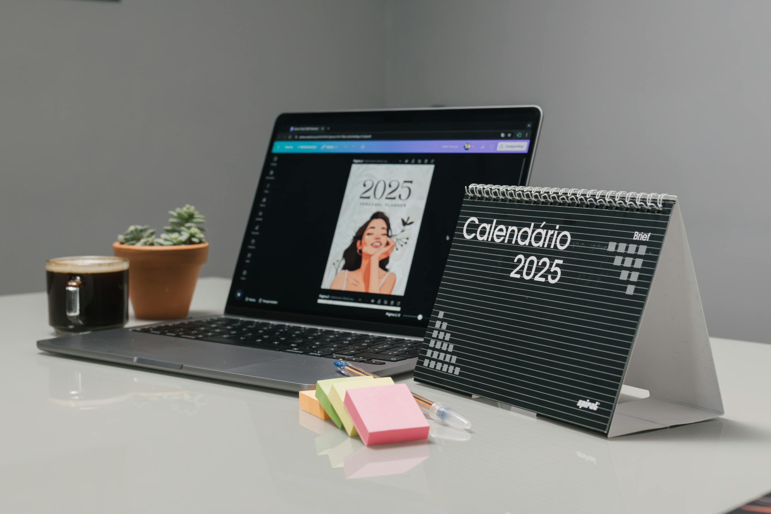 Modern office desk featuring a 2025 calendar, laptop, and coffee for a productive work environment.